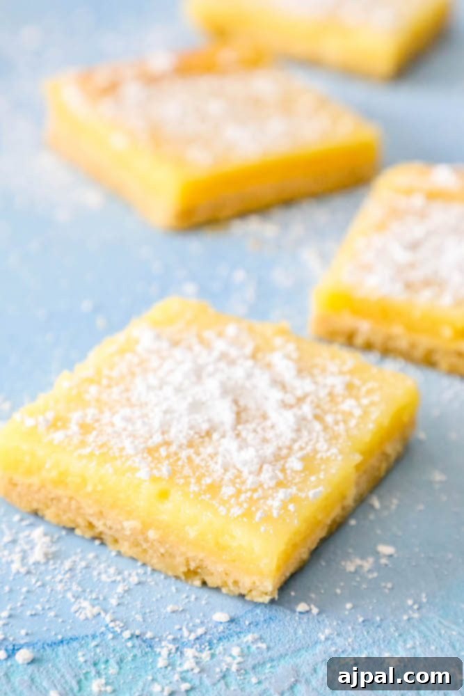 Picture of several lemon bars artfully arranged on a table, displaying their golden crust and creamy topping.