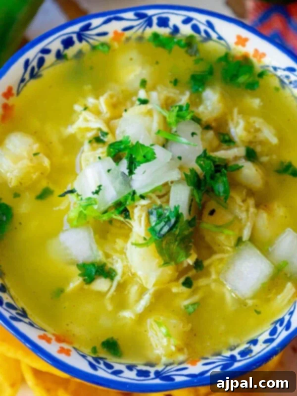 A bowl of Chicken Posole Verde with fresh toppings.