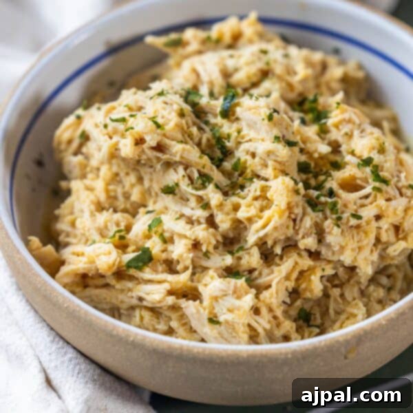 A bowl of perfectly boiled shredded chicken, garnished with fresh herbs, suitable for a Keto diet.