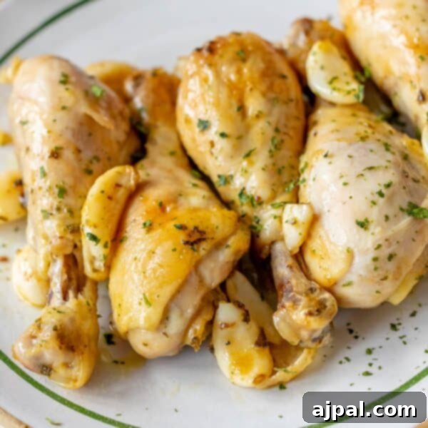 A plate of roasted Greek chicken drumsticks with herbs and garlic.