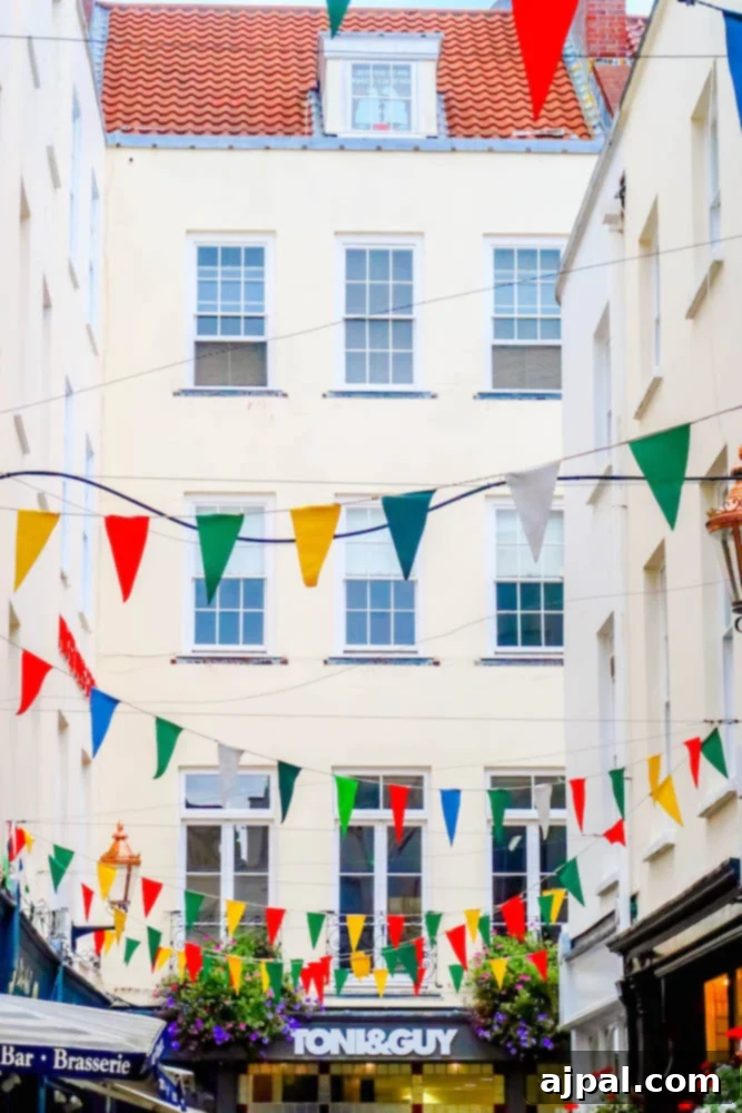 A charming street in Guernsey, UK, adorned with vibrant buntings, exuding a festive atmosphere perfect for a British Isles Cruise.