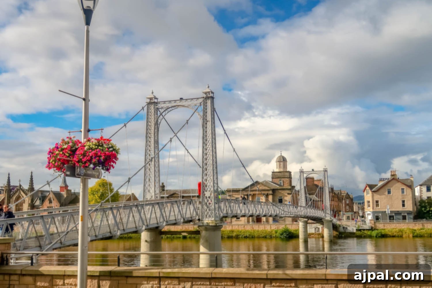 Book a British Isles Cruise: Your Adventure Awaits 4 A picturesque bridge adorned with baskets of colorful flowers, connecting two parts of a charming British Isles town.