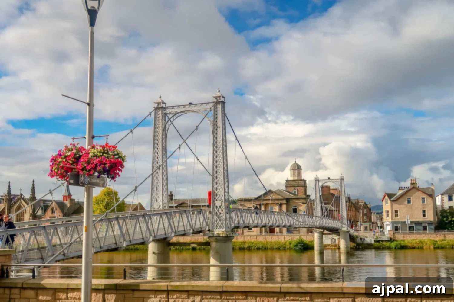 A picturesque bridge adorned with baskets of fragrant flowers, connecting vibrant landscapes in the British Isles.