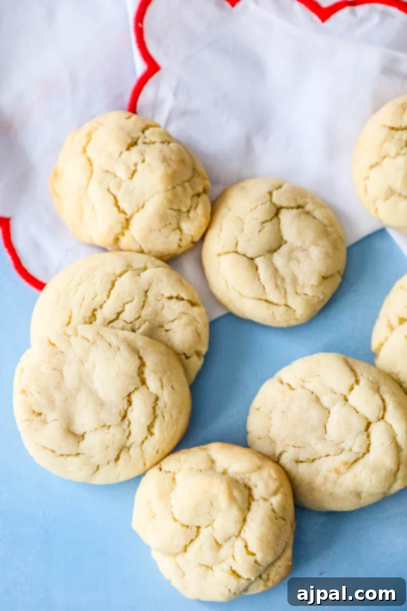 Unforgettable Chewy Sugar Cookies Easy Recipe 6 A group of soft, pillowy sugar cookies artfully arranged on a blue background.