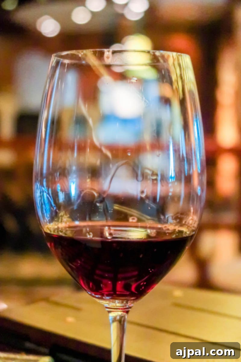 West Coast Majesty: A Royal Princess Voyage 7 A glass of red wine on a wooden table aboard the Royal Princess Cruise.