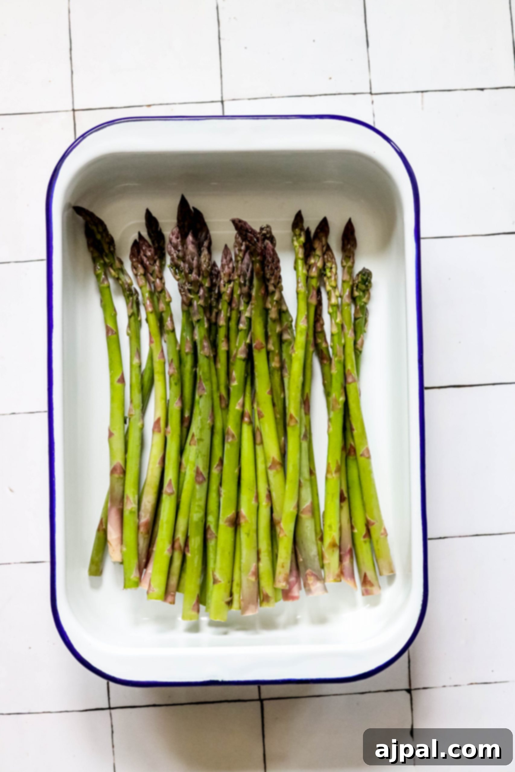 Crispy Roasted Asparagus 5 Freshly seasoned asparagus spears ready for roasting on a baking sheet