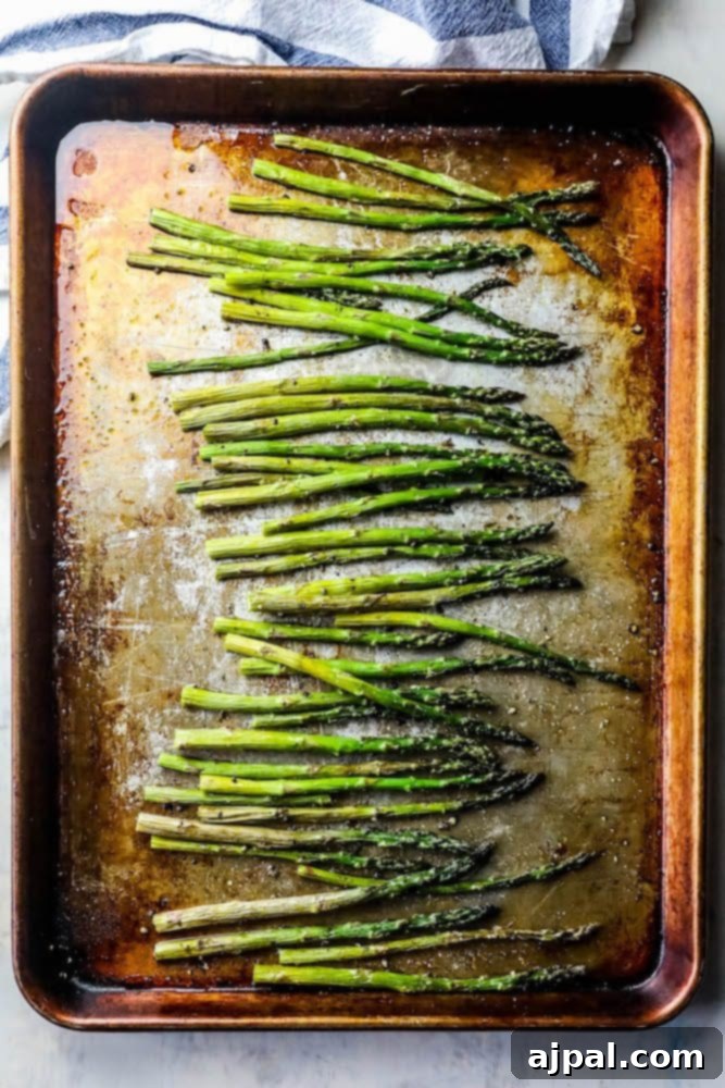 Crispy Roasted Asparagus 6 A close-up of beautifully roasted asparagus on a white sheet pan