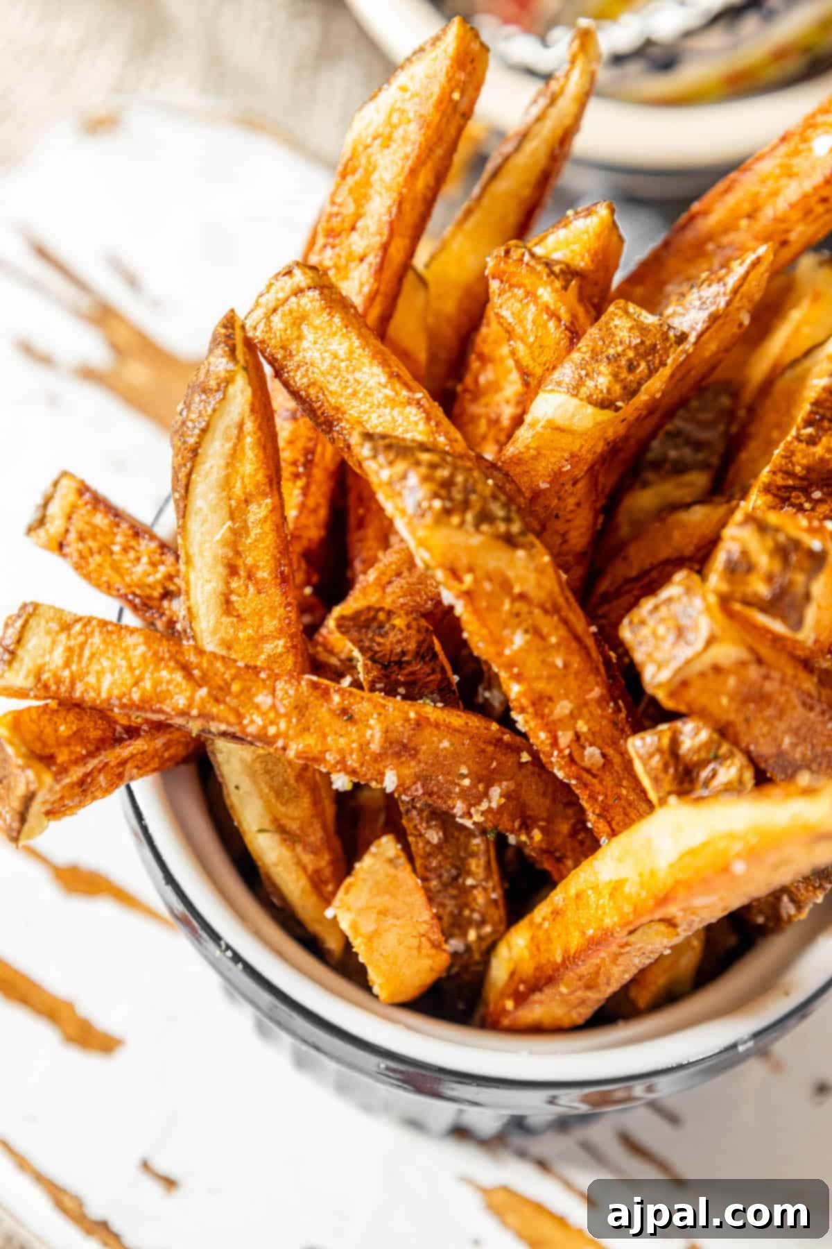 Crispy sweet potato fries served in a bowl on a table.