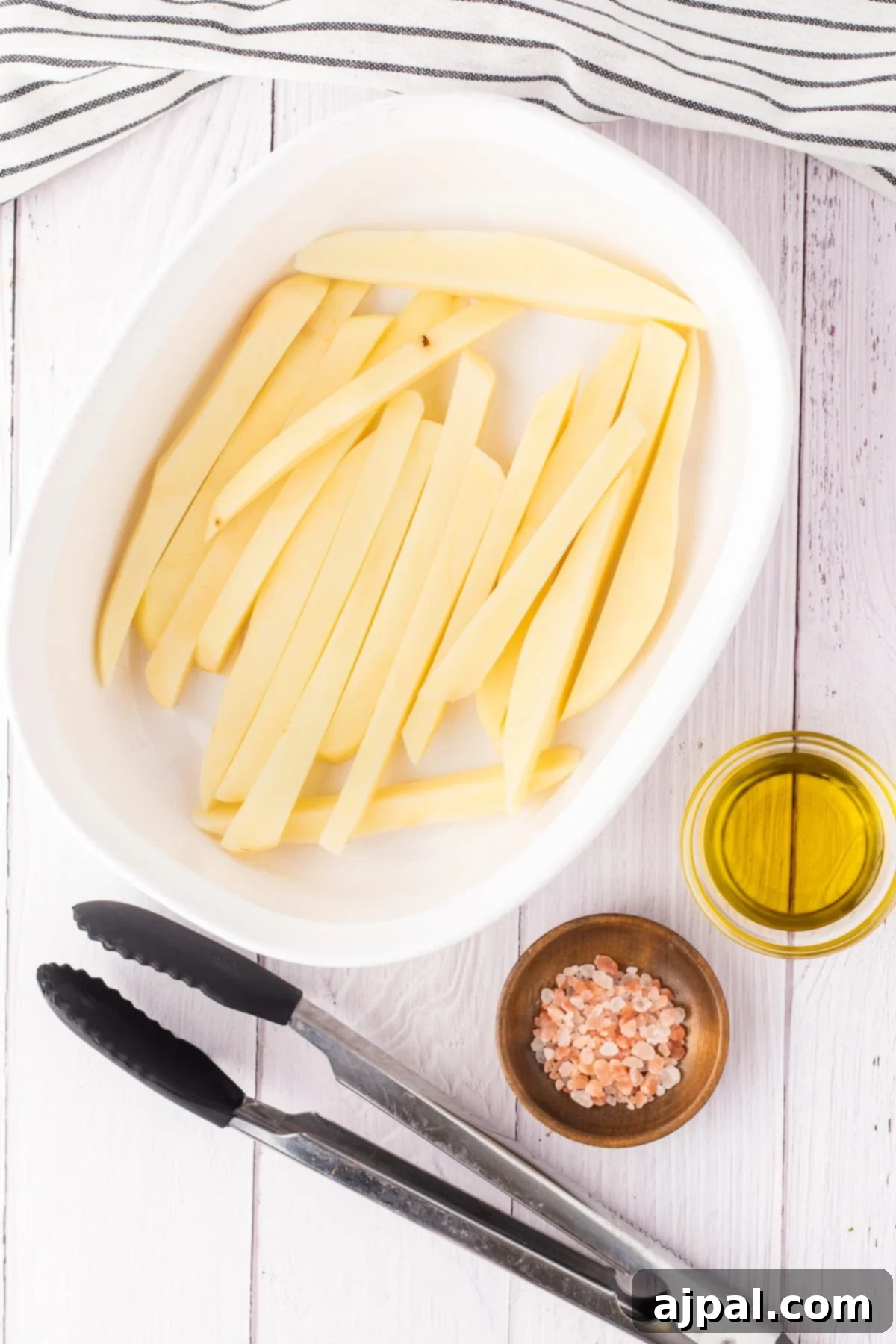 potato tossed in salt and oil in a dish