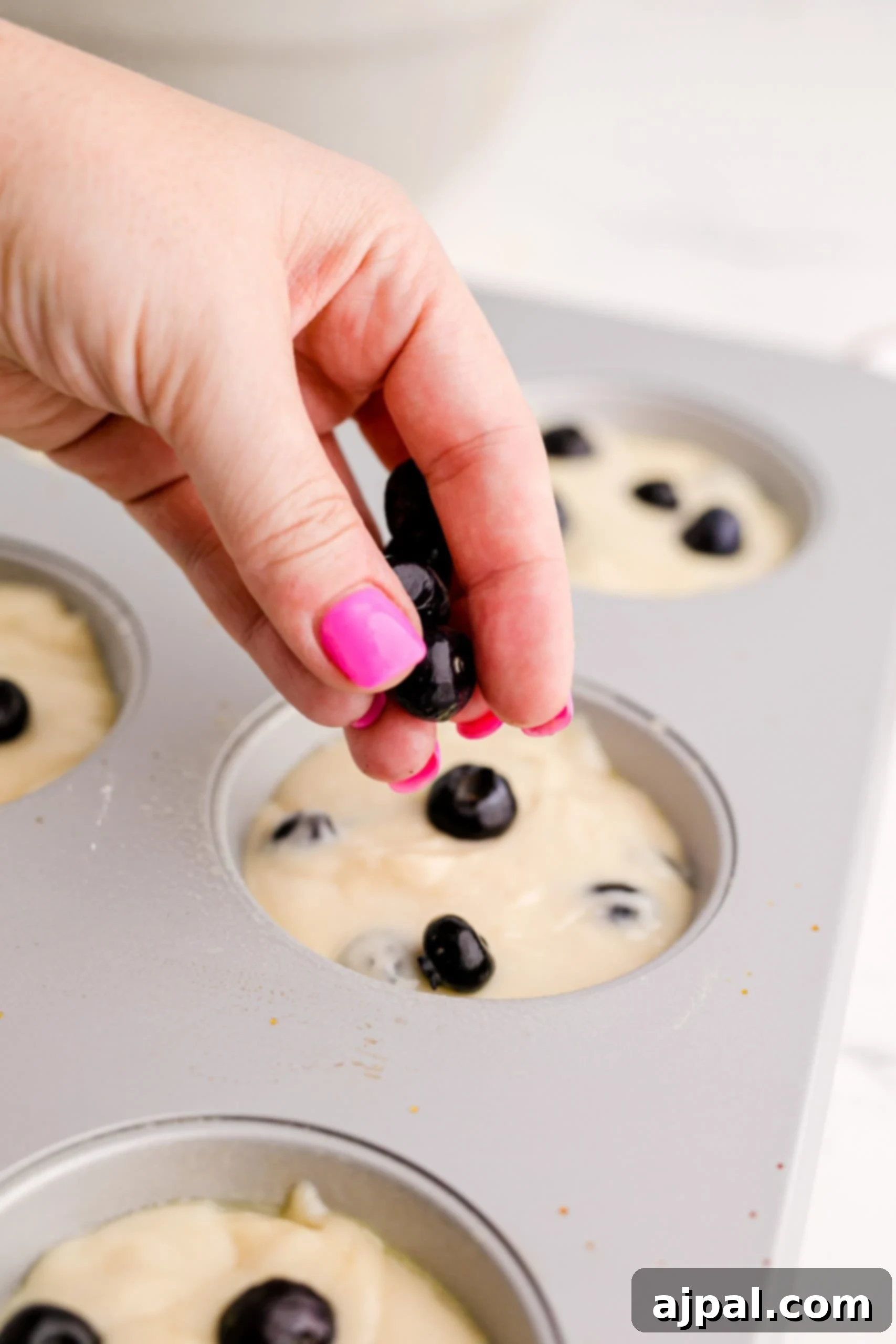 A person making Blueberry Muffins.