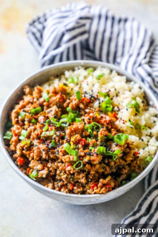 A beautifully arranged Keto Teriyaki Rice Bowl with seasoned ground turkey and a base of cauliflower rice, garnished with vibrant green onions, ready for a healthy meal.