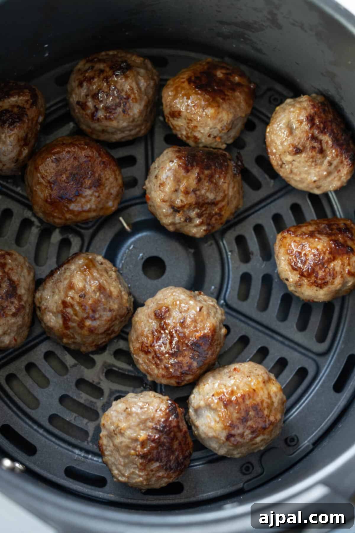 Meatballs cooking in air fryer basket, an easy meatballs recipe perfect for those seeking keto meatballs without breadcrumbs.