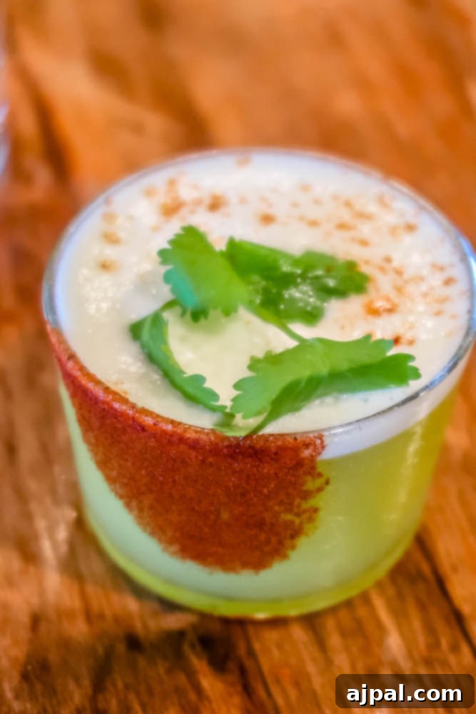 Idyllic Santa Ynez Valley Getaway 14 A vibrant and spicy margarita garnished with cilantro, served on a rustic wooden table at S.Y. Kitchen in Santa Ynez.