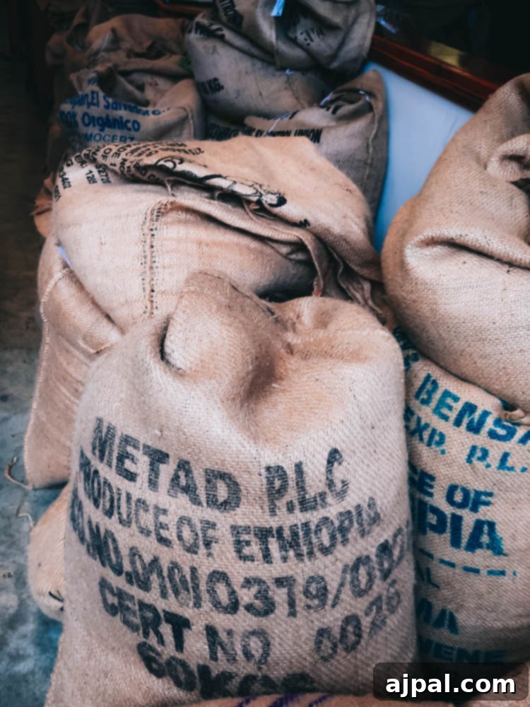 A group of sacks of coffee sitting on a floor, emphasizing the key ingredient for delicious coffee at JoeBella Roasters in Atascadero.