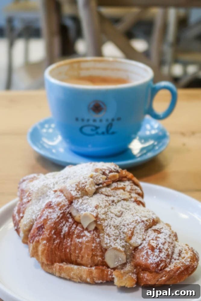 A croissant on a plate next to a cup of coffee in Santa Monica.