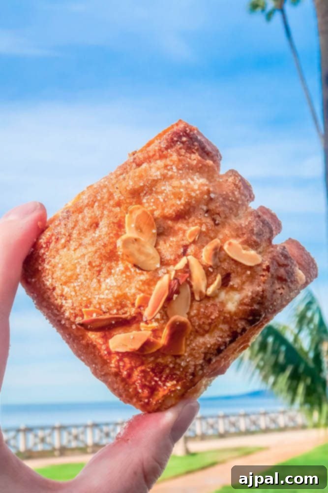 A person holding a piece of bread in front of a palm tree during Santa Monica Restaurant Week.