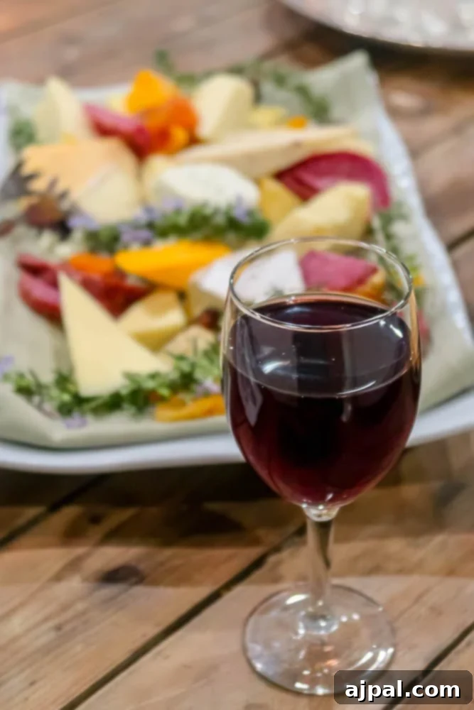 A plate of cheese and wine on a wooden table highlighting the culinary delights of Los Alamos within Santa Ynez Valley.
