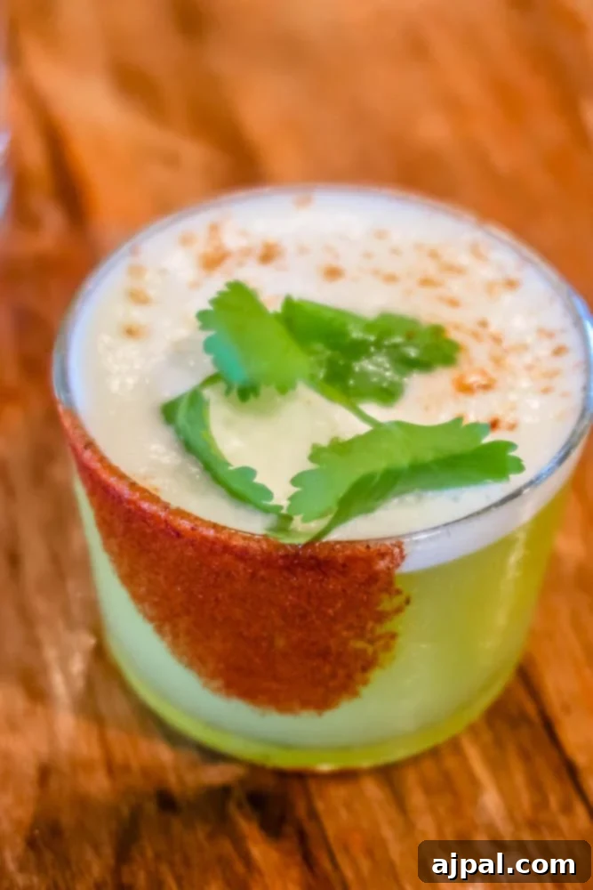 A refreshing lime drink with cilantro garnish served on a rustic wooden table at a winery in Los Alamos, California.