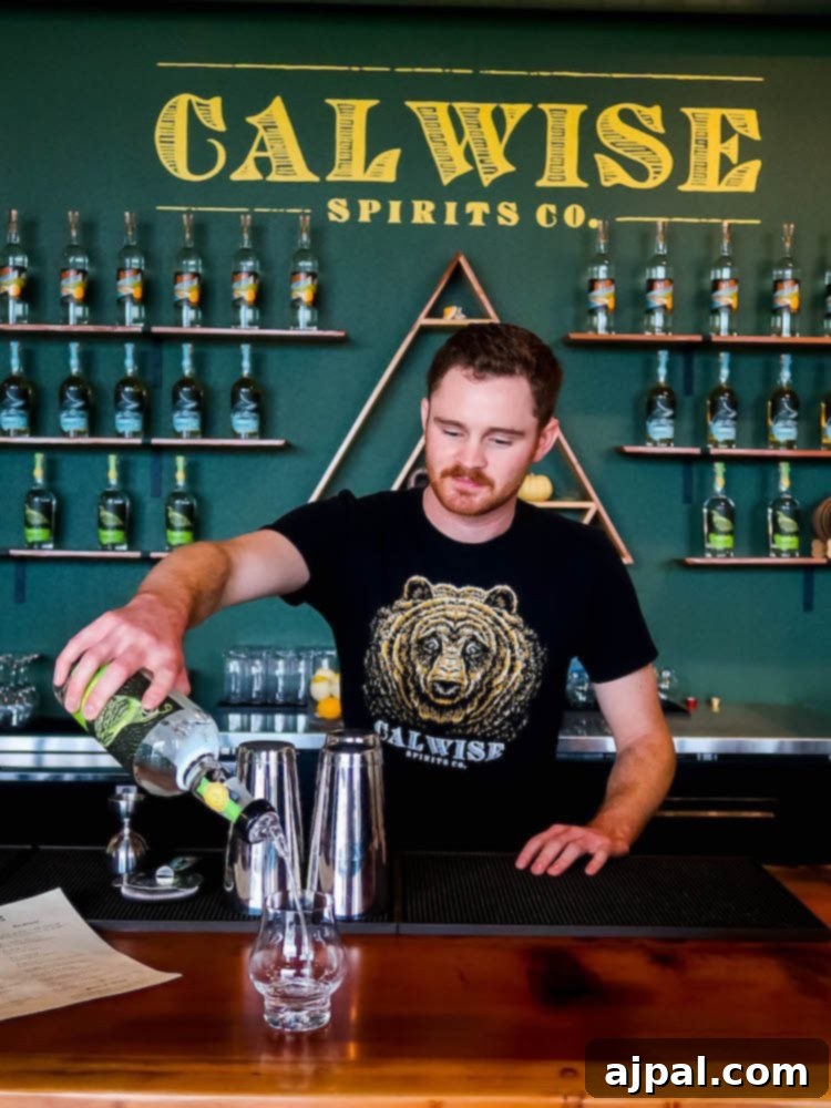 A man pouring a drink at the bar of Calwise Spirits Co., the perfect place to taste and stay in Paso Robles.