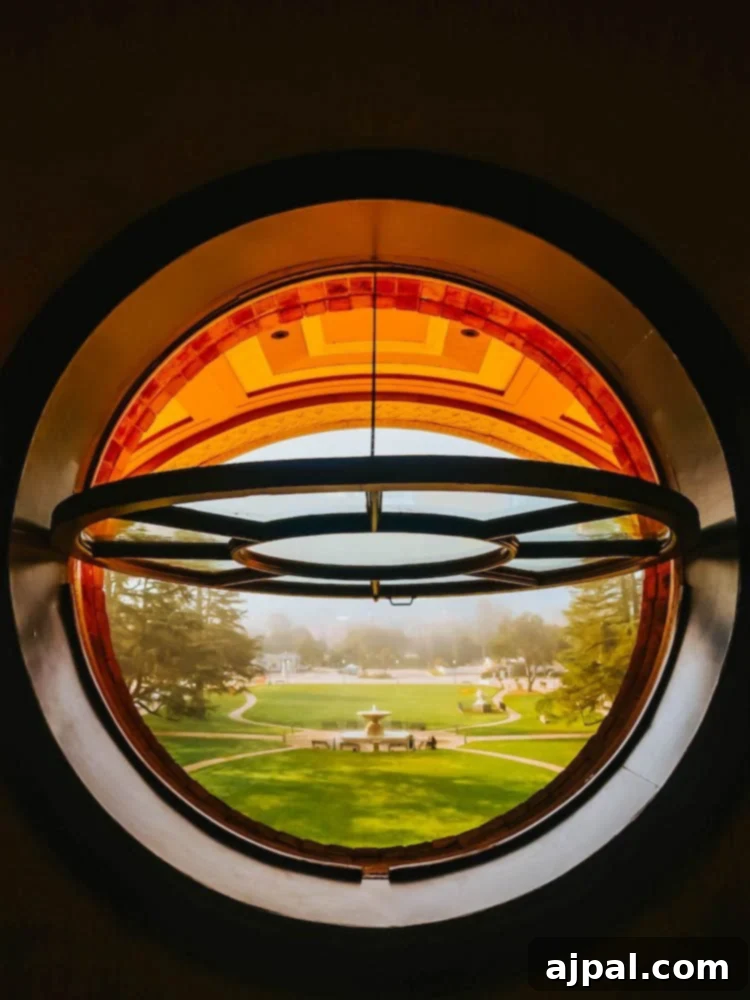 A circular window with a view of a field in Atascadero.