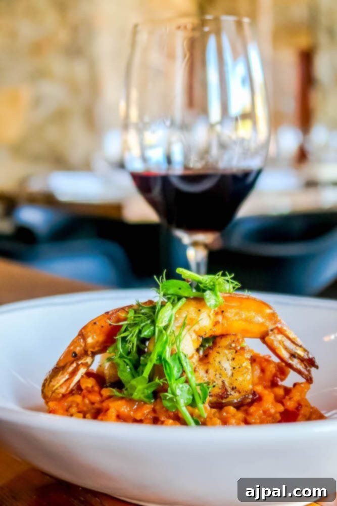 A plate of shrimp and rice paired with a glass of red wine, perfect for what to eat in Atascatero.
