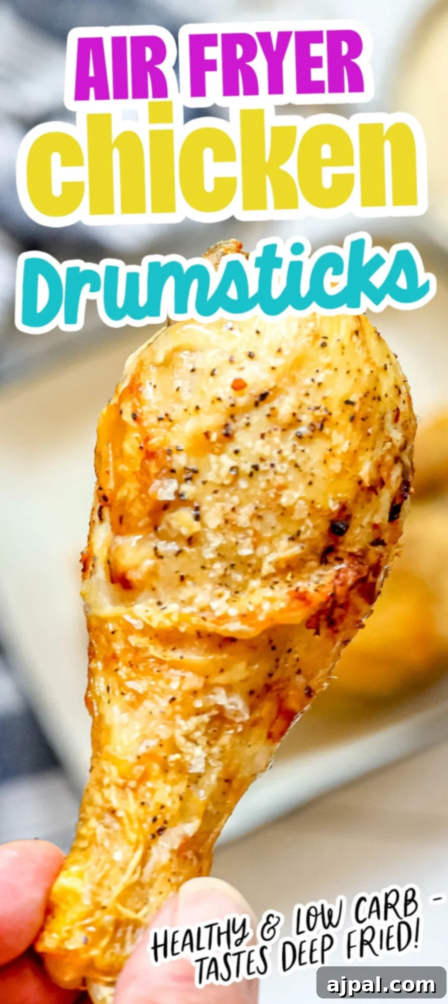 picture of a hand holding an air fried chicken drumstick