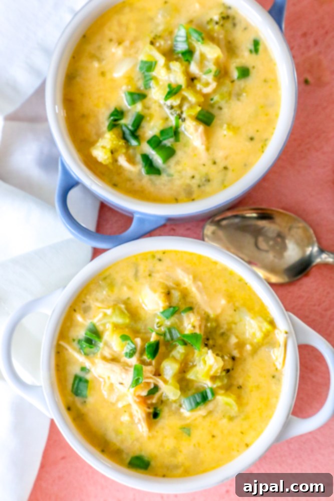 Creamy Chicken Broccoli Cheese Soup 2 Two bowls of the best easy cheesy chicken and broccoli soup on a table. One blue, one white.