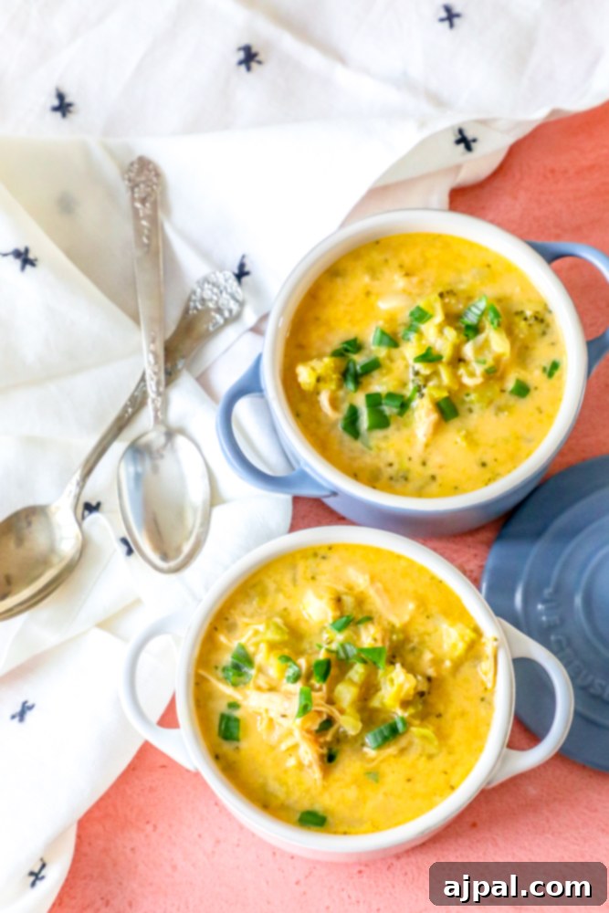 Creamy Chicken Broccoli Cheese Soup 4 Two white and blue bowls filled with savory cheesy chicken broccoli soup on a wooden table.
