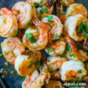 air fried shrimp on a plate covered in parmesan and garlic with chopped parsley