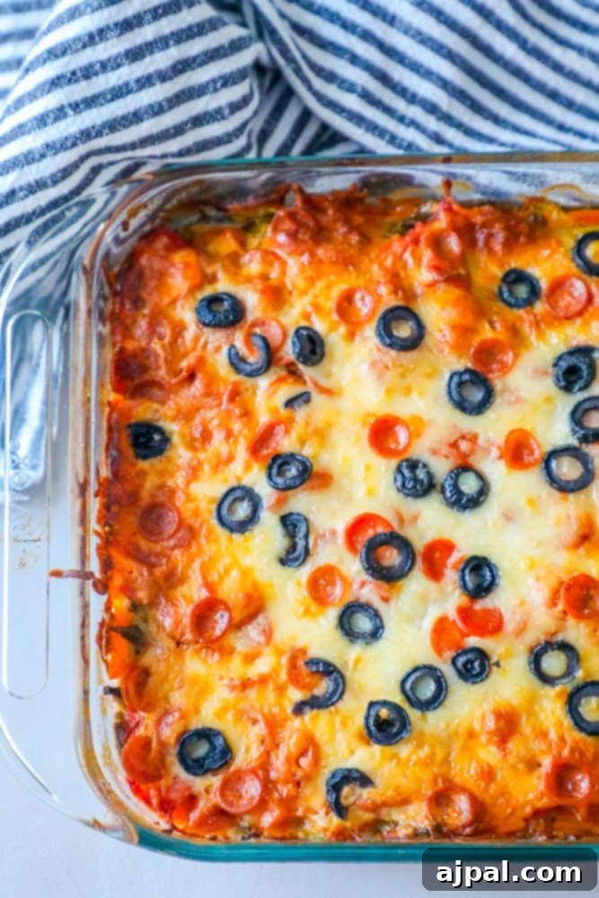Ultimate Cheesy Pizza Bake 4 A hearty serving of Cheesy Keto Pizza Casserole, showcasing the melted cheese, sliced pepperoni, and black olives, ready to be enjoyed.