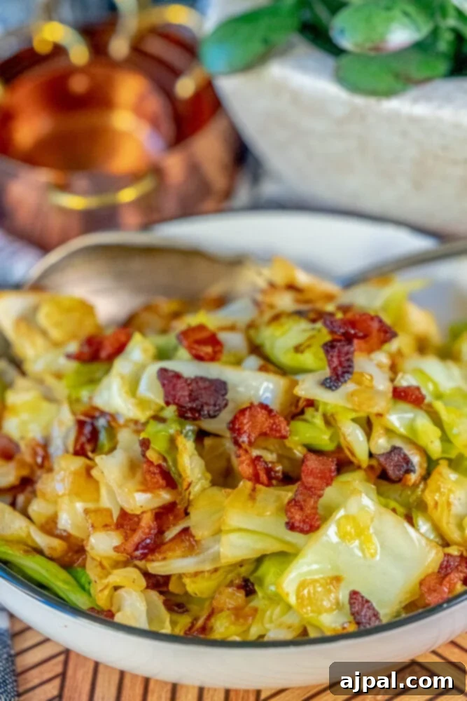 Browned cabbage and bacon in a white bowl, glistening with butter.