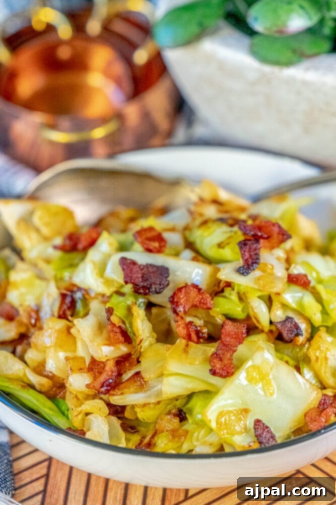 Pan fried cabbage and bacon in a white bowl, ready to be enjoyed.
