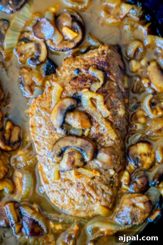 Tender Cube Steak Smothered in Savory Gravy 4 A hearty and flavorful keto-friendly cube steak dish, served with a rich mushroom and onion gravy, presented in a rustic cast-iron skillet.