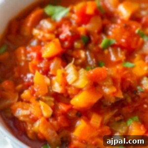 A bowl of tomato soup on a table with Creole Sauce.