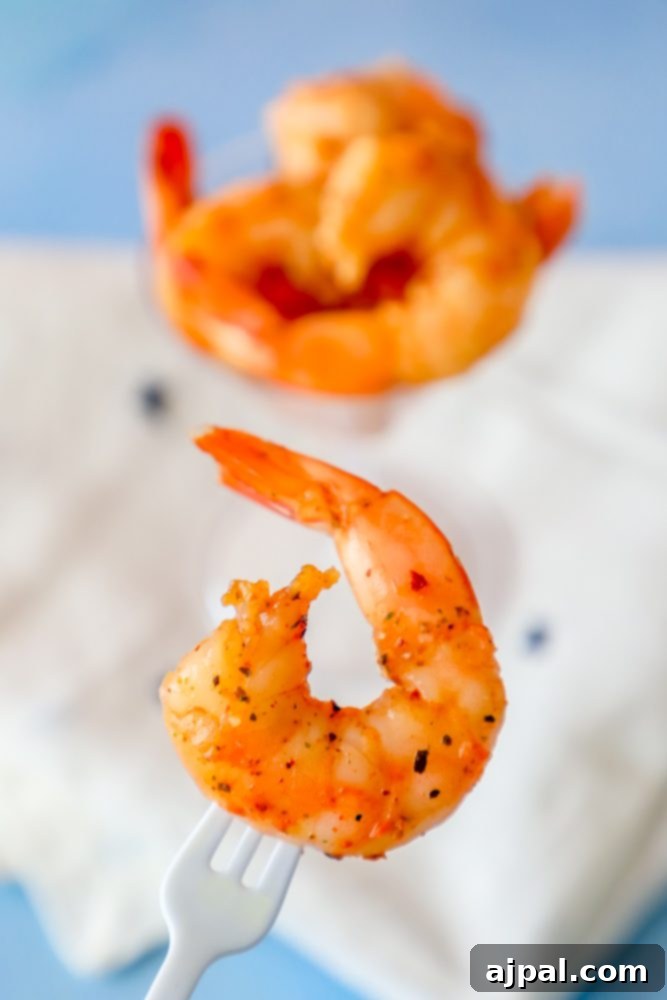 A fork holding a piece of perfectly seasoned Cajun shrimp, inviting a taste.