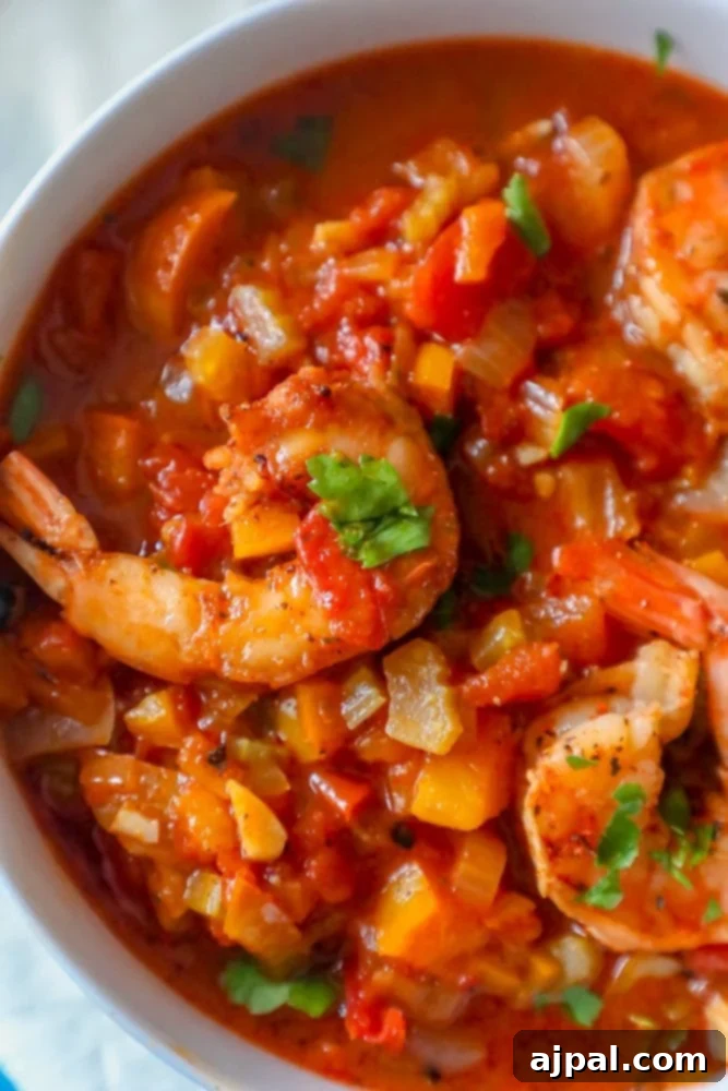 A flavorful one-pot shrimp stew in a bowl on a table, garnished with fresh herbs.