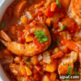 A bowl of Creole shrimp stew with diced vegetables and garnished with fresh parsley.
