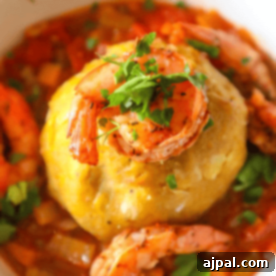A bowl of food with shrimp and polenta.
