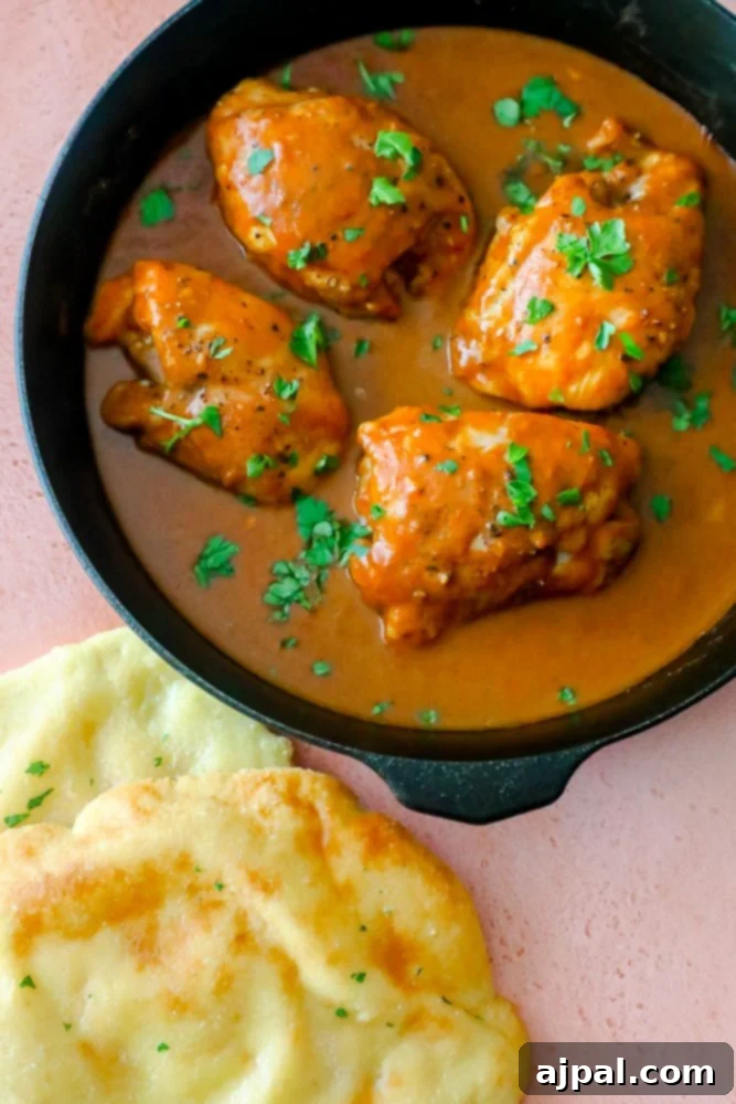 chicken with orange sauce and cilantro on it in a skillet