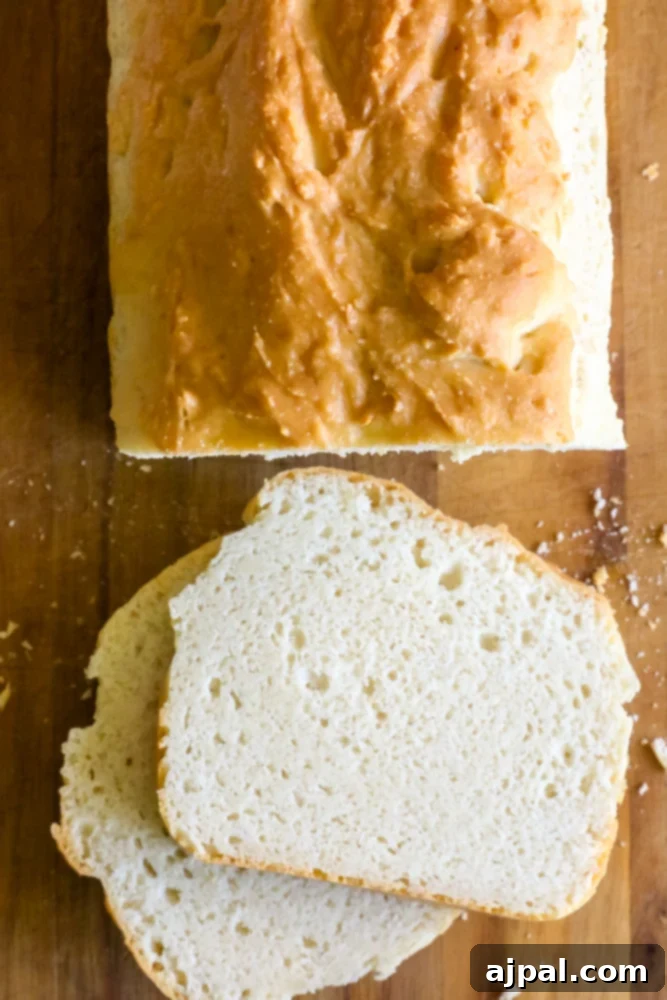 Effortless Keto Sandwich Loaf 6 Easy low carb bread recipe on a wooden cutting board, cooling after baking.