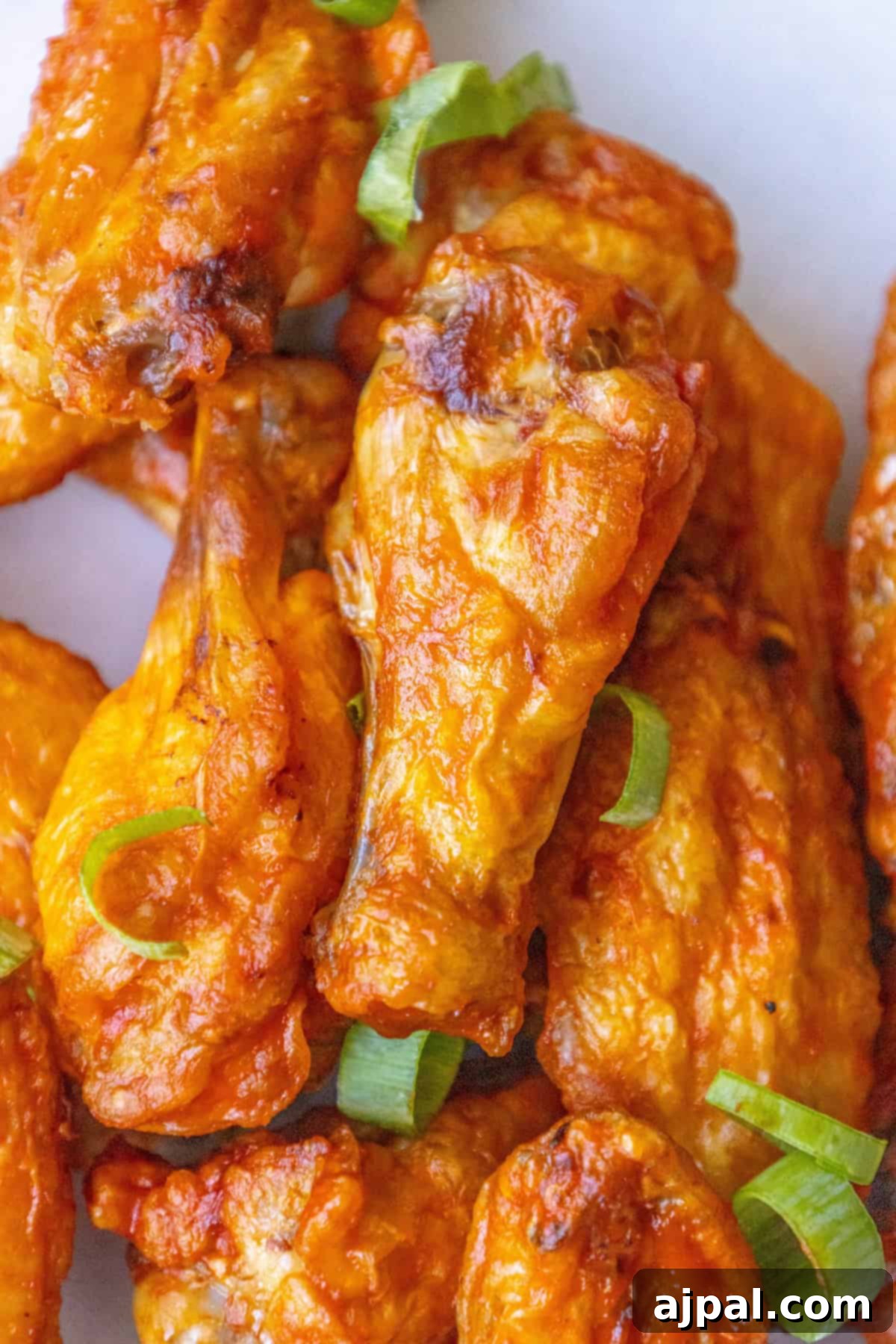 A vibrant platter of crispy oven-baked chicken wings, perfectly golden brown, garnished with fresh herbs, ready to be served as an irresistible appetizer or main dish.
