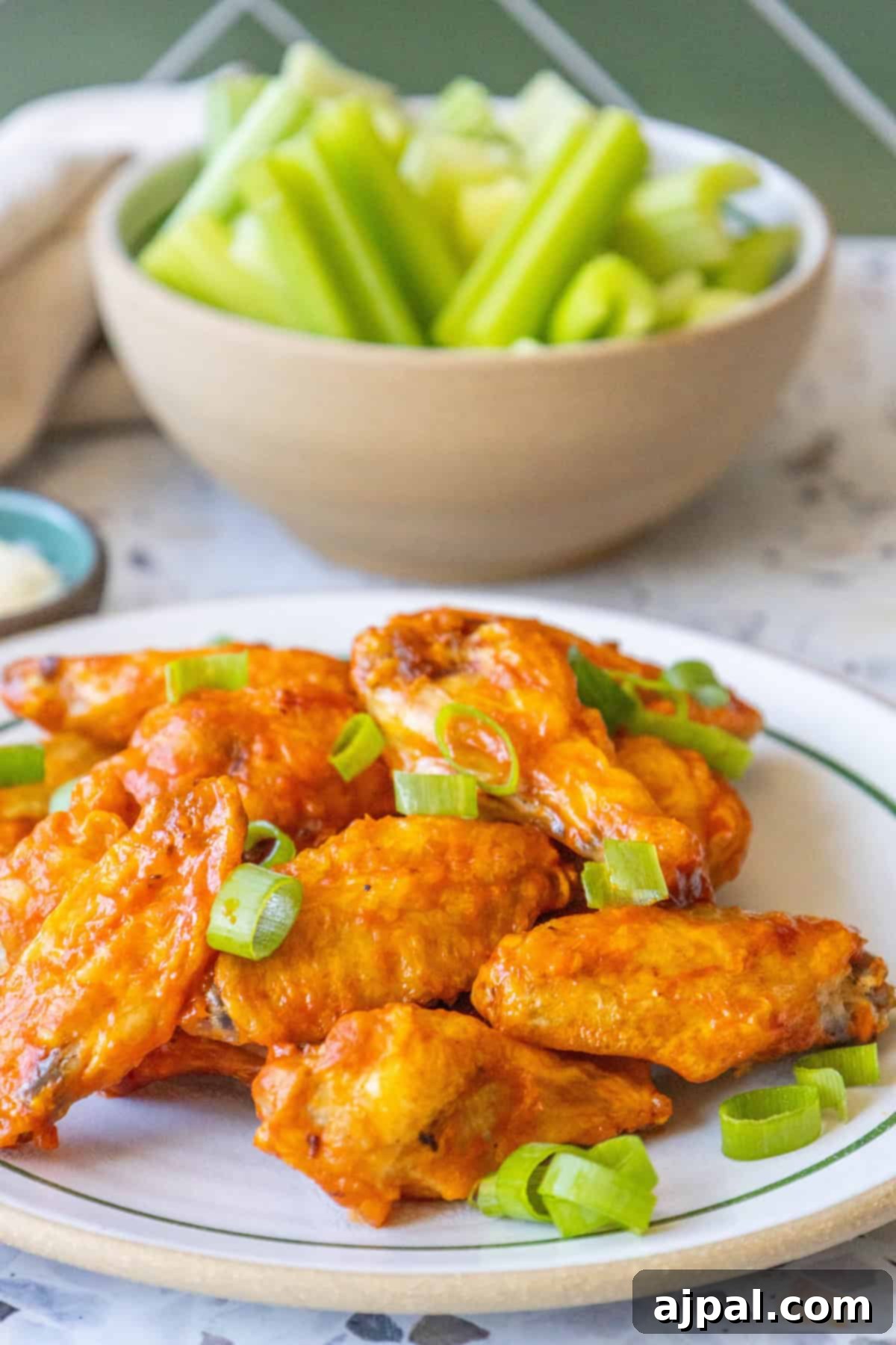A close-up of several crispy baked chicken wings on a serving dish, highlighting their golden-brown skin and succulent appearance.