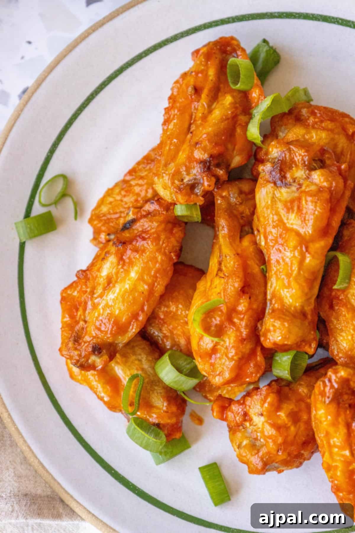 A close-up of oven-baked crispy chicken wings on a rack, showing their golden-brown color and inviting texture.