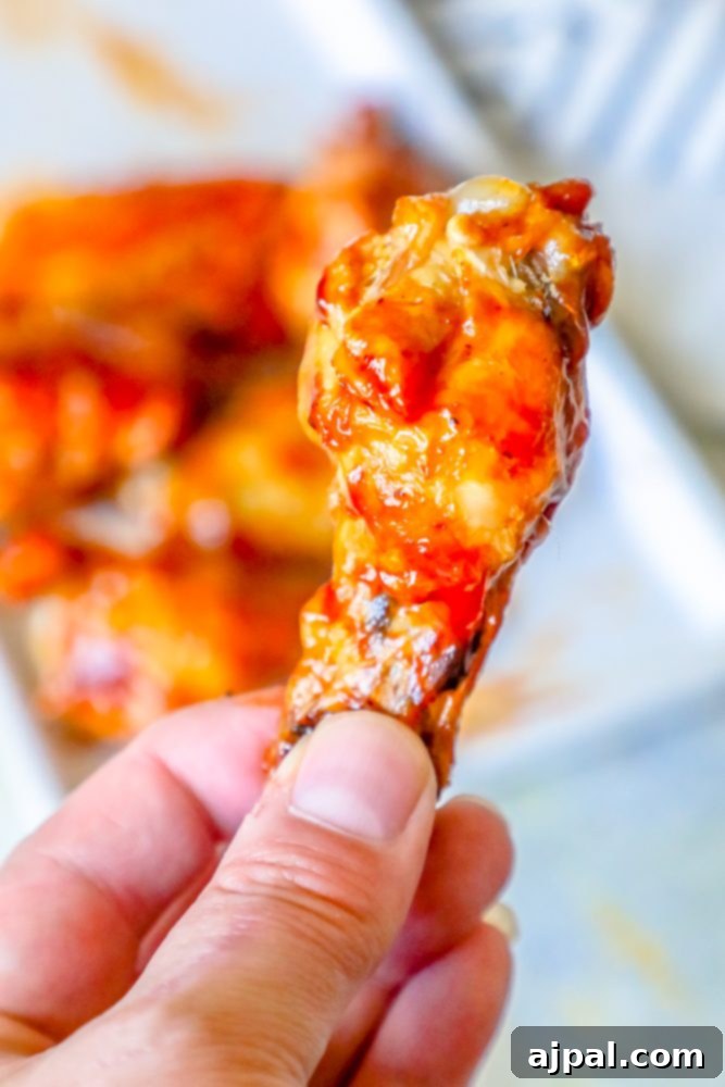 Crispy Oven BBQ Chicken Wings 3 chicken wings with red sauce on them