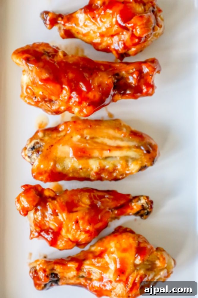 Crispy Oven BBQ Chicken Wings 4 chicken wings with red sauce on them