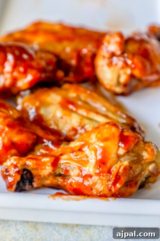 Crispy Oven BBQ Chicken Wings 5 chicken wings with red sauce on them