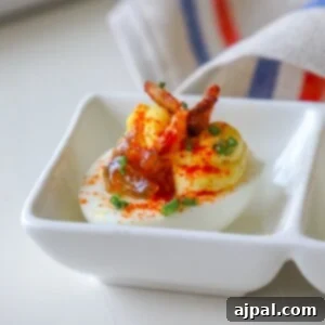 Keto deviled eggs garnished with bacon and topped with onion jam.