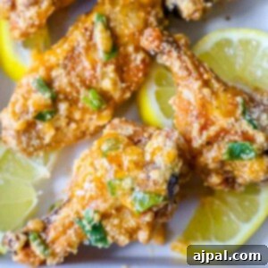 picture of lemon garlic parmesan chicken wings on a plate with lemon slices