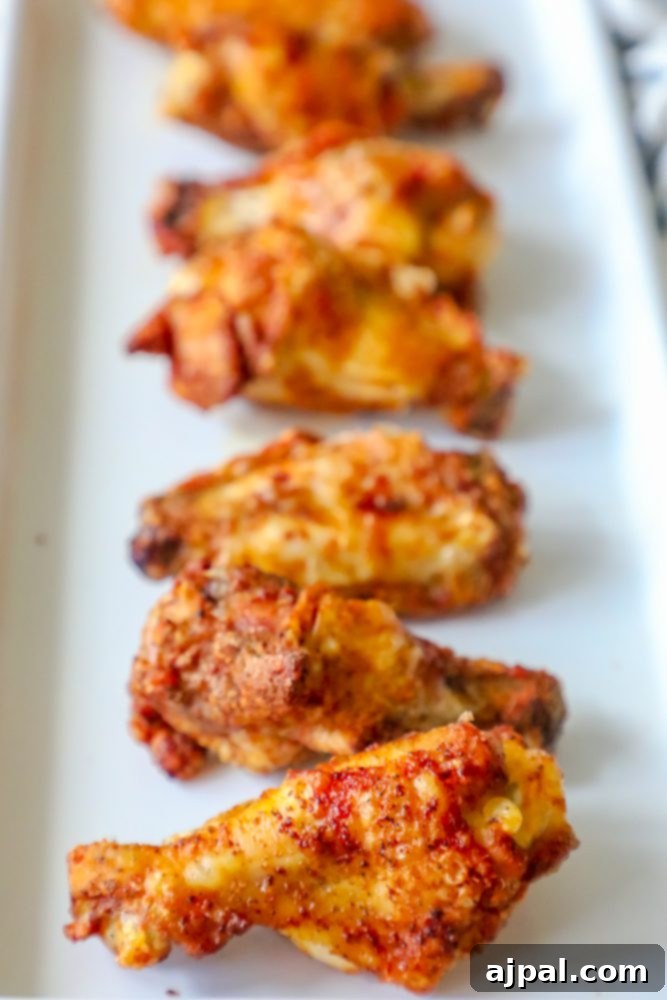 Spicy Cajun Baked Chicken Wings 2 Dry rub baked chicken wings on a white plate, showcasing their crispy texture.