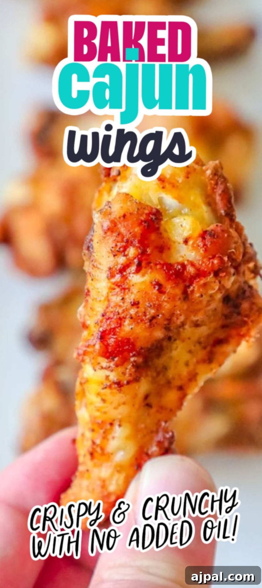 Spicy Cajun Baked Chicken Wings 8 Crispy baked chicken wing being held by a hand, demonstrating its perfect crunch.